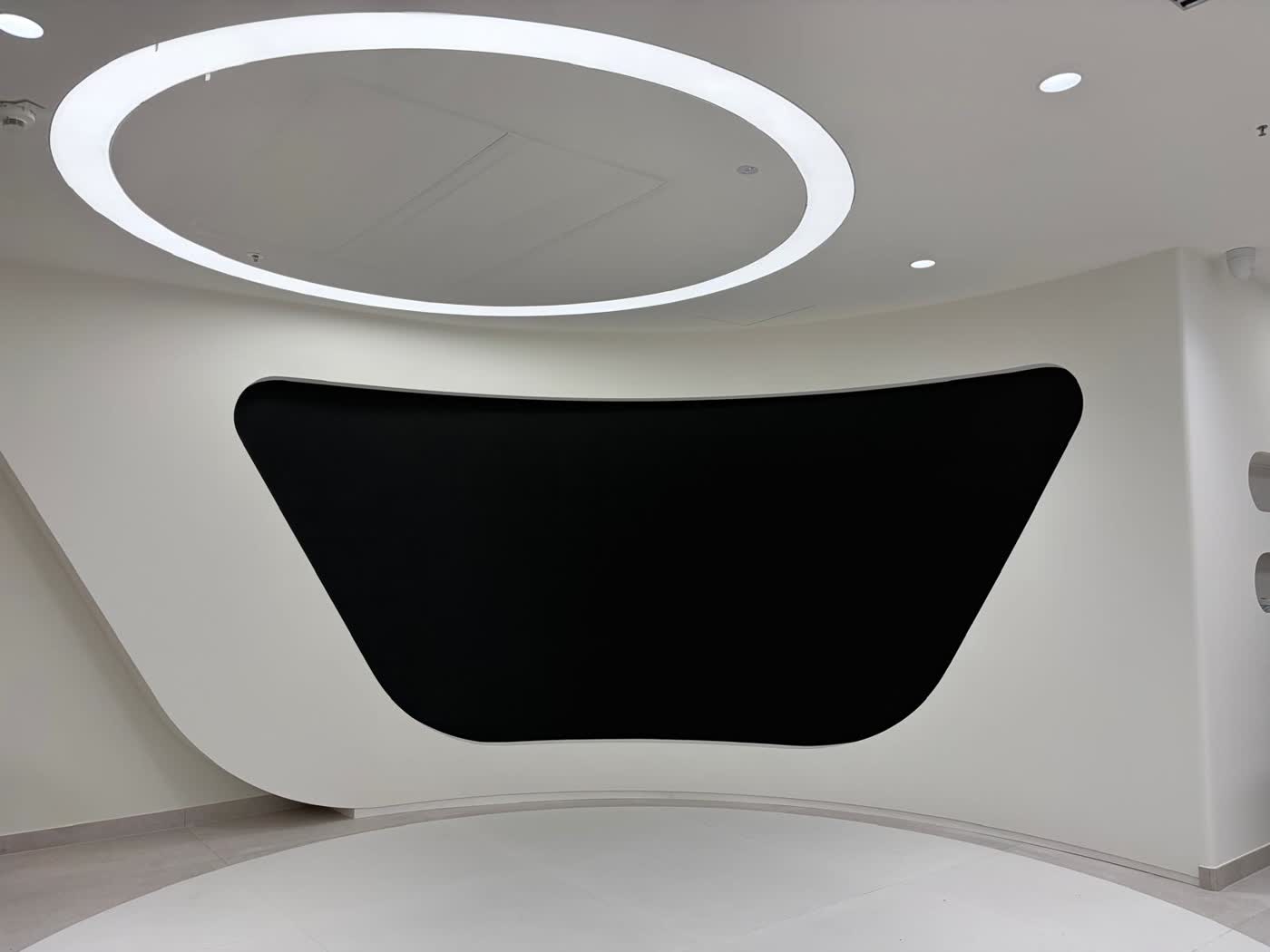 Geschwungene LED-Medienfläche in weißer Wandarchitektur