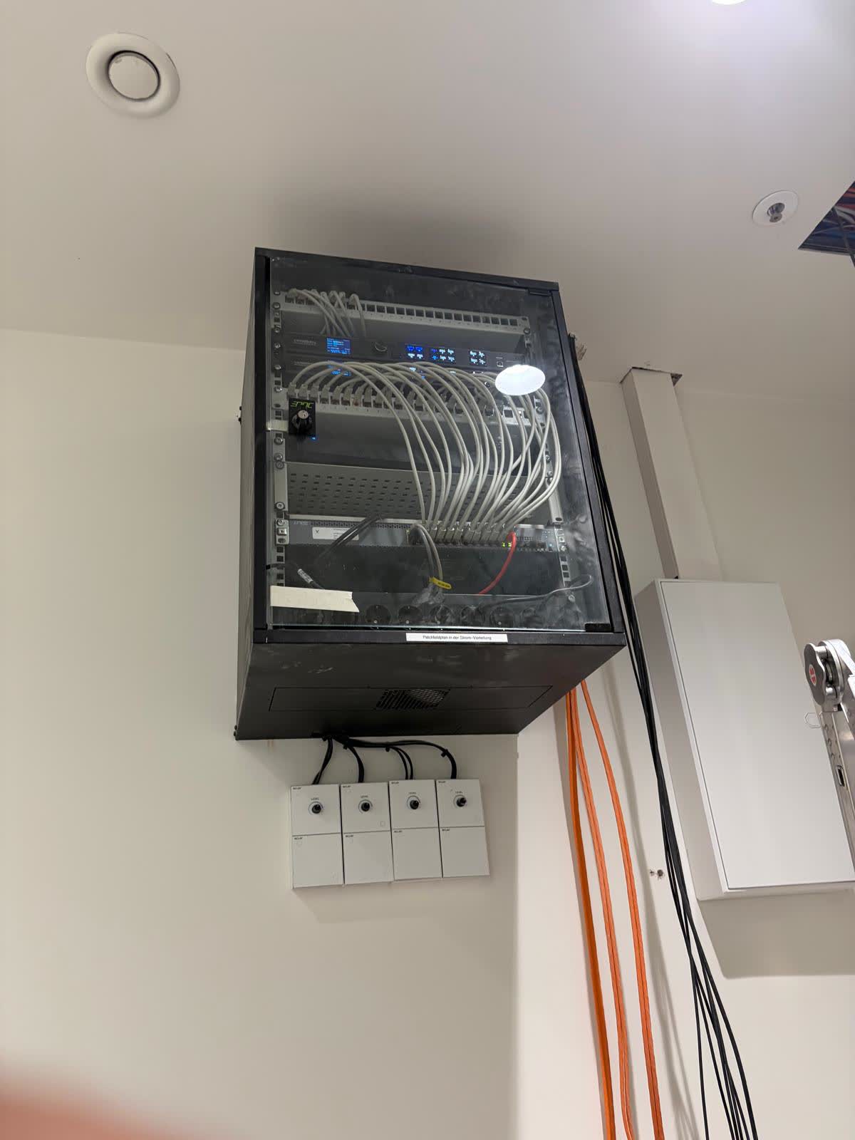 Wandmontiertes Netzwerk- und Medienrack mit sauber gepatchter Verkabelung